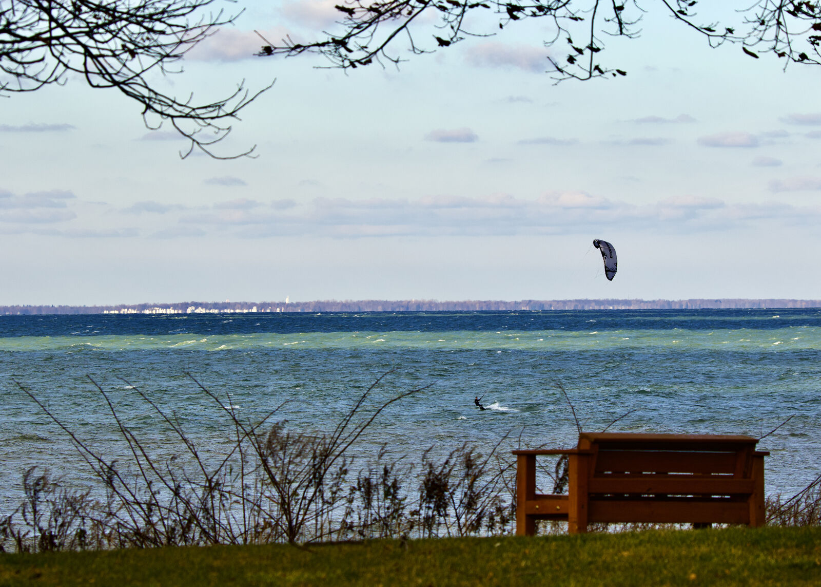 Kitesurfer on Lake Erie viewed from a park bench in Evans