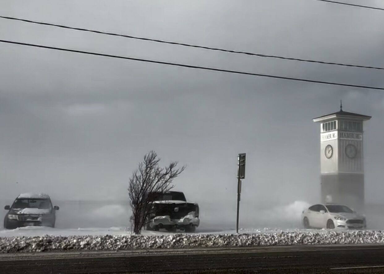 Hamburg clock tower seen through blowing snow along the roadside